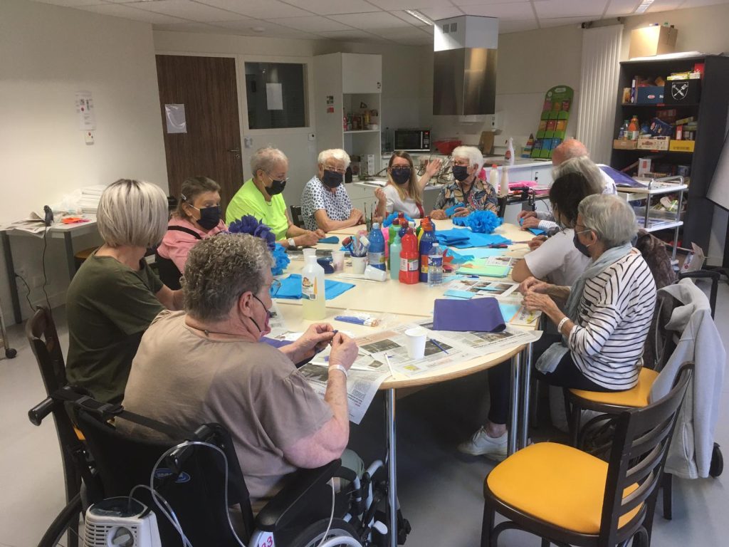 Personnes autour d'une table pour créer des objets avec l'ergothérapeute